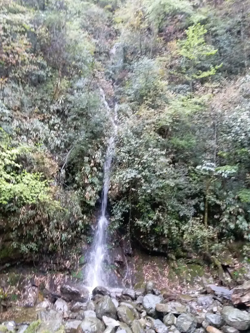 A waterfall cascades down the cliff of Mount Fanjing